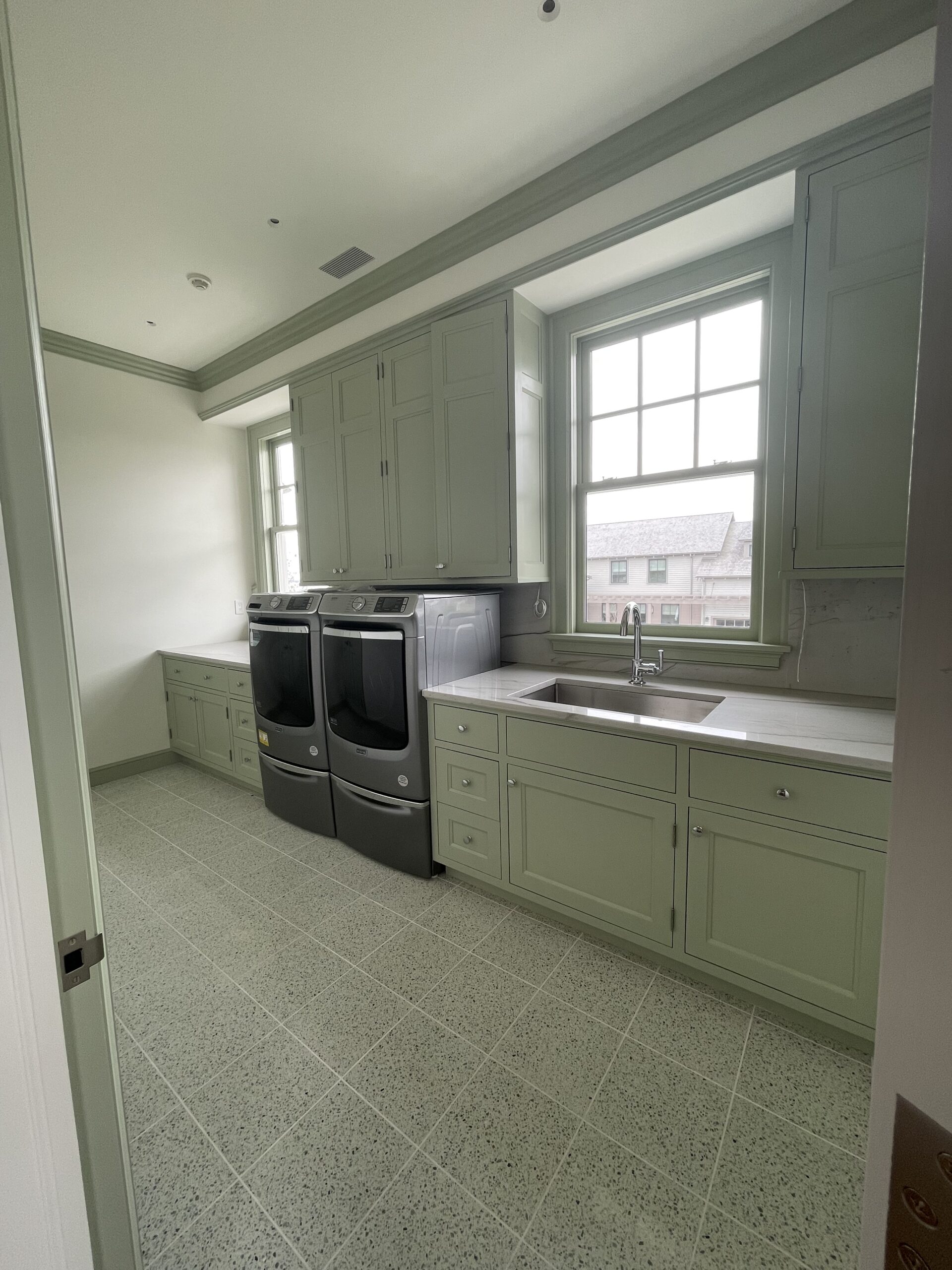 Luxury laundry room with custom cabinetry, finished by L&J Painting Group