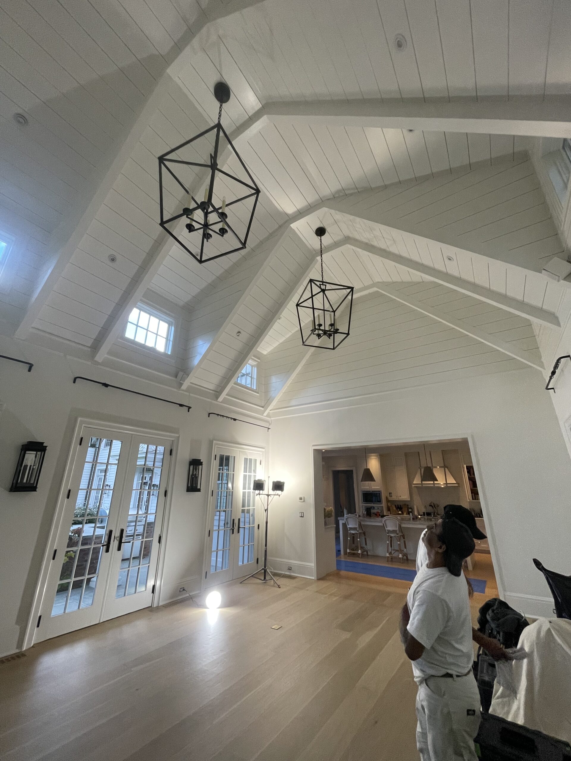 L&J Painting Group crew member assessing a freshly painted vaulted great room ceiling