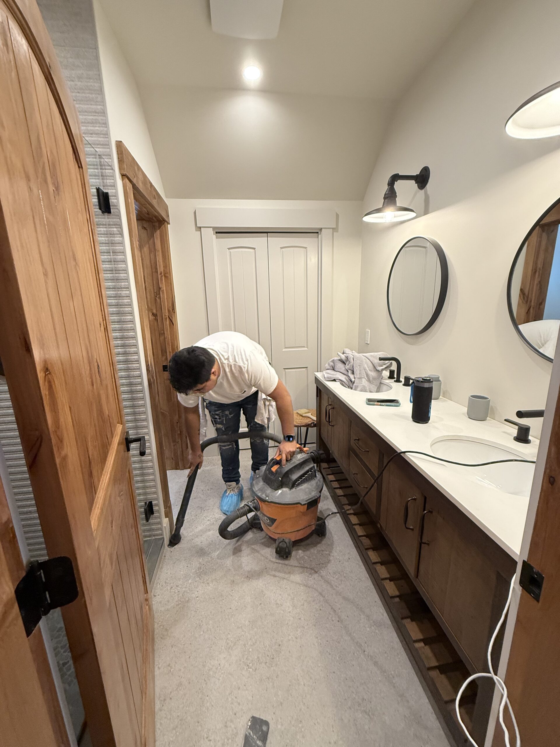 L&J Painting Group crew member completing final cleanup in a finished primary bathroom