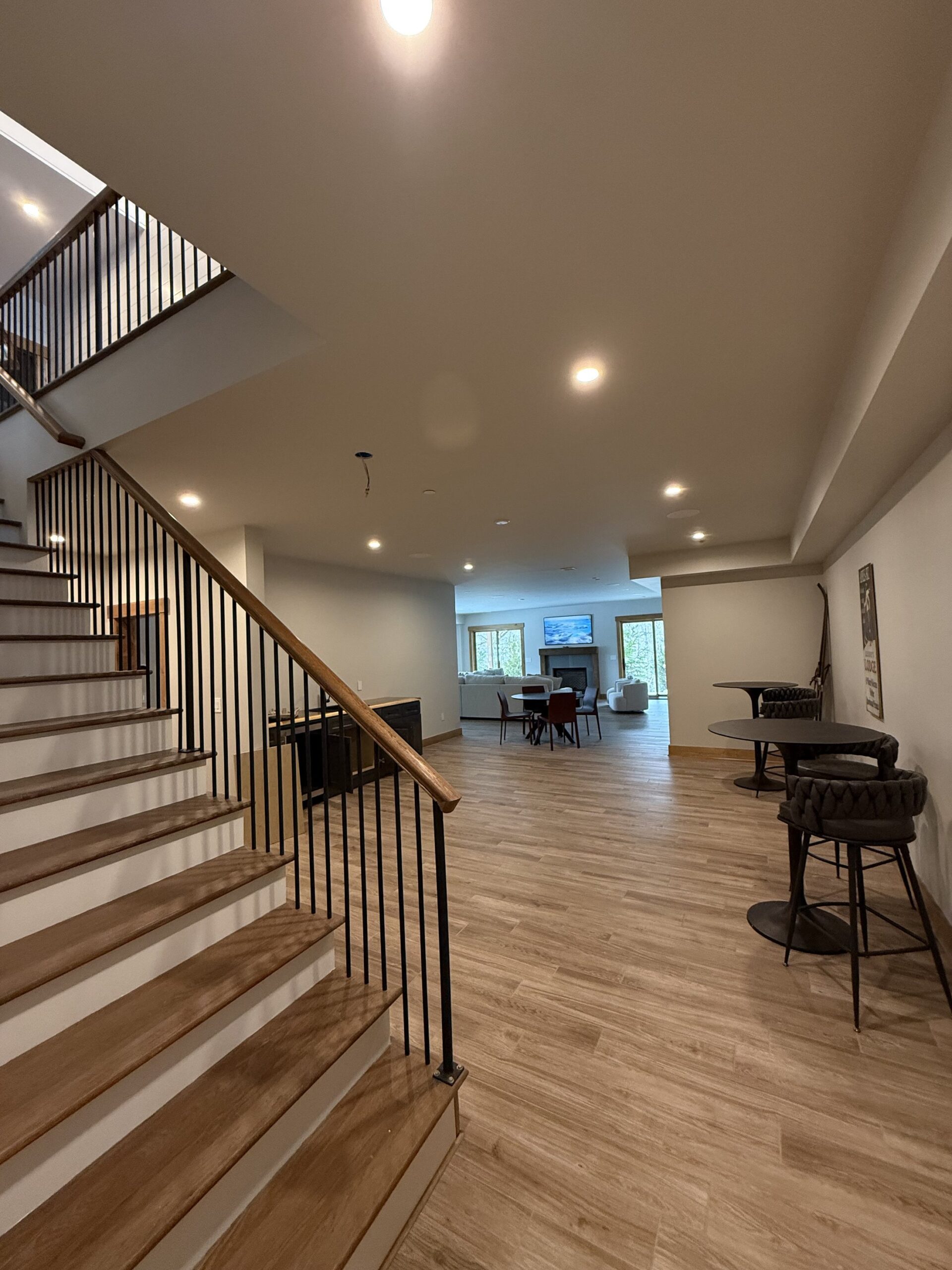 Grand vaulted great room with floor-to-ceiling stone fireplace and wood beam ceiling, finished by L&J Painting Group