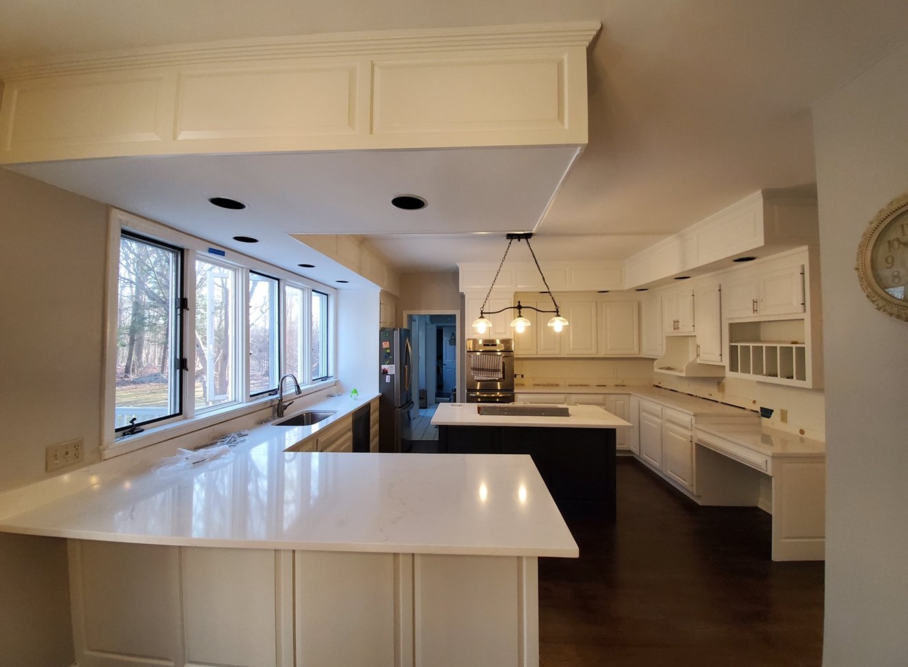 Finished white kitchen cabinetry with waterfall island, cabinet painting by L&J Painting Group