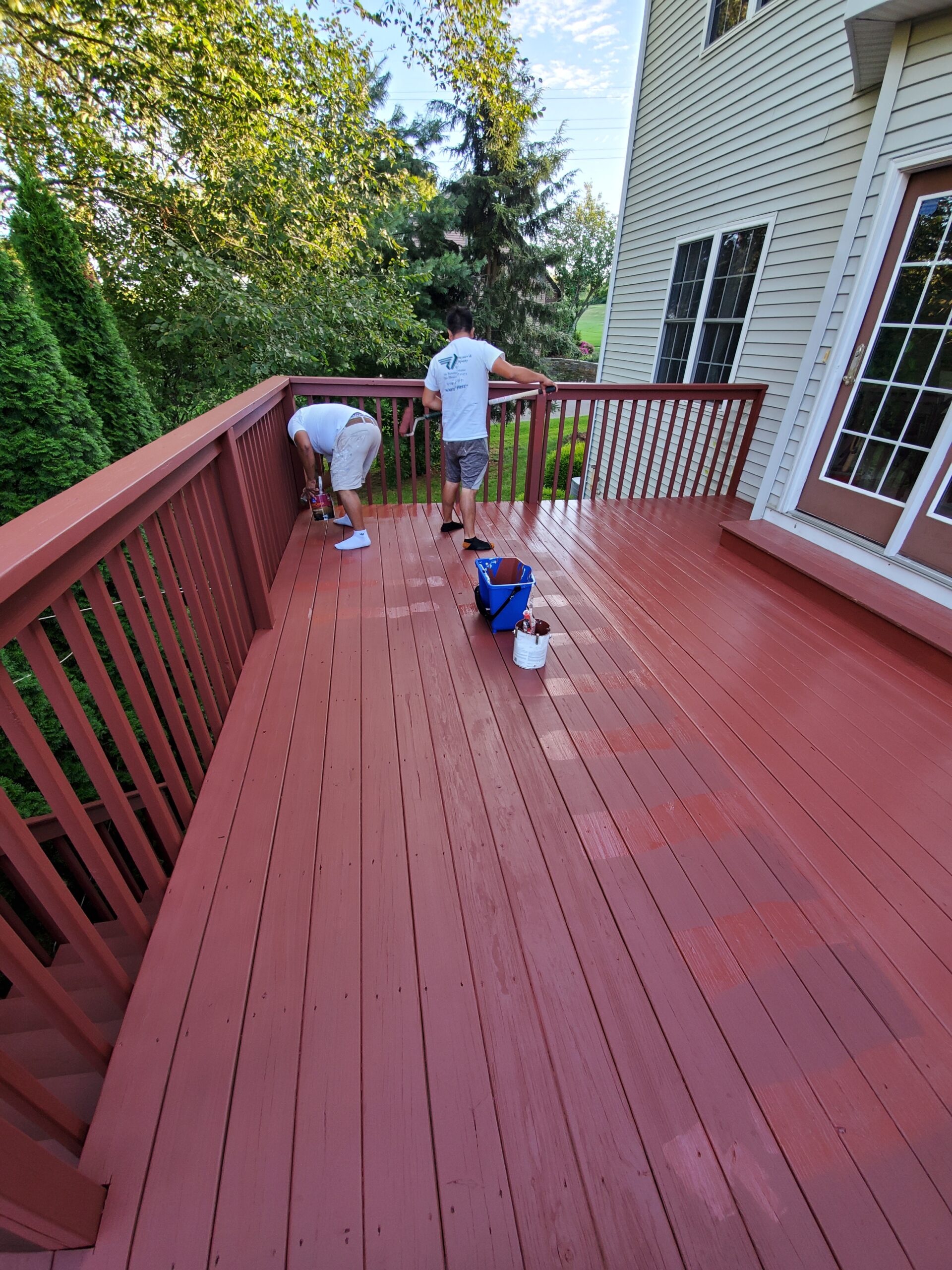 L&J Painting Group crew staining a large deck