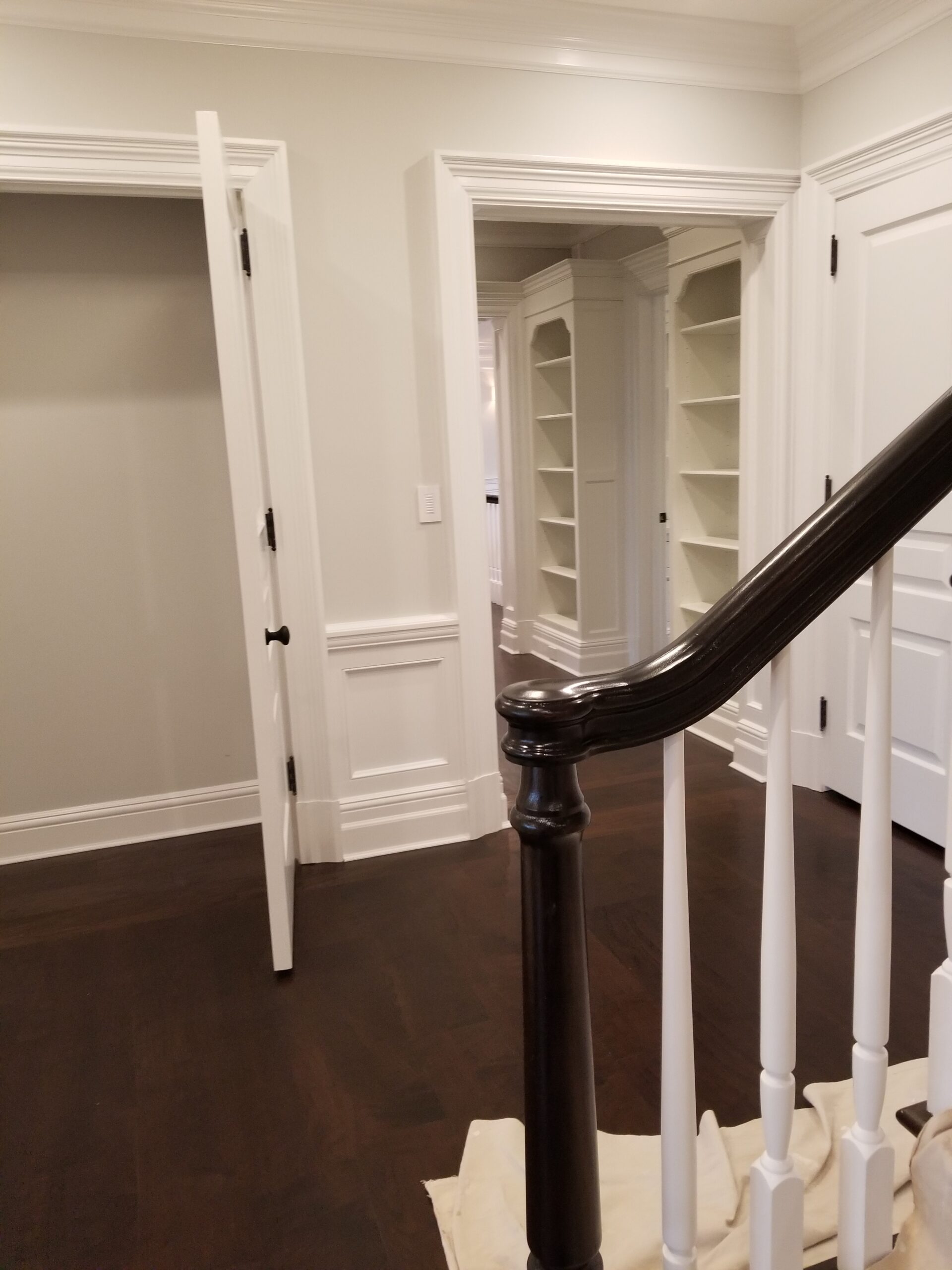 Elegant staircase landing with built-in library nook, finished by L&J Painting Group